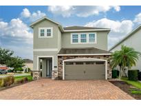 Two-story house with stone accents and a two-car garage at 7694 Graben St, Kissimmee, FL 34747