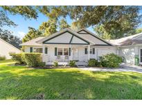 Cozy ranch home with a covered porch and green lawn at 8666 Sw 92Nd Ln # E, Ocala, FL 34481