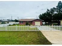 Brick home with white picket fence and well-maintained lawn at 16 Spring Drive Way, Ocala, FL 34472