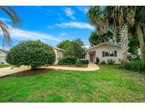 Single-story house with a well-maintained lawn and walkway at 17521 Se 96Th Ct, Summerfield, FL 34491