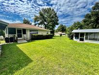 Spacious backyard with grassy area and detached screened structure at 2323 Ne 98Th St, Anthony, FL 32617