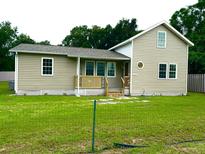 Tan house exterior with green lawn and walkway at 1510 Nw 48Th St, Ocala, FL 34475