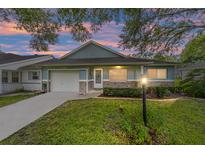 Charming one-story home with a brick facade and landscaped lawn at dusk at 9692 Sw 95Th Ct # D, Ocala, FL 34481