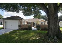 One story home with attached garage and mature landscaping at 7296 Sw 115Th Pl, Ocala, FL 34476