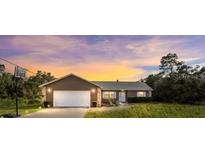 House exterior at dusk, featuring a brown color scheme and a basketball hoop at 15735 Sw 52Nd Avenue Rd, Ocala, FL 34473