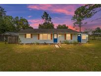 Charming ranch home with blue door and landscaping at 12353 Sw 61St Place Rd, Ocala, FL 34481