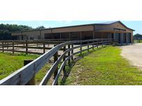 Large barn with riding arena and fenced pastures at 2051 Se 155Th St, Summerfield, FL 34491