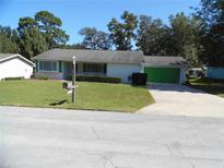 Single story home with green garage door and well maintained lawn at 9223 Sw 109Th Ln, Ocala, FL 34481