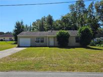 Single-story home with a one-car garage and well-maintained lawn at 4 Spring Trl, Ocala, FL 34472