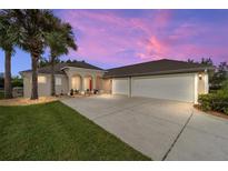 House exterior with three-car garage and palm trees at 6470 Sw 50Th Ct, Ocala, FL 34474