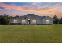 Stunning two-story house with a large lawn under a beautiful sunset at 5615 Nw 202Nd Pl, Mc Intosh, FL 32664