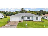 One-story house with a gray roof and white garage door; spacious yard at 2051 Nw 50Th Ave, Ocala, FL 34482