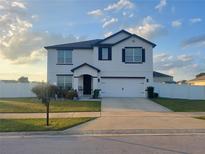Two story home with white siding, dark trim, and a two car garage at 4551 Ne 27Th St, Ocala, FL 34470