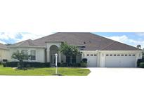 Beautiful one-story home with a three-car garage and lush landscaping at 5858 Nw 27Th Pl, Ocala, FL 34482