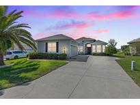 Beautiful home with driveway and landscaping at sunset at 12333 Se 177Th Loop, Summerfield, FL 34491