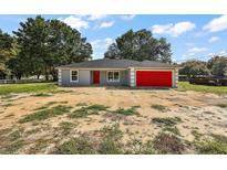 Newly built home with red garage door and gray siding at 13780 Sw 114Th Ln, Dunnellon, FL 34432