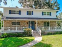 Two-story house with brick and white siding, a covered porch, and a manicured lawn at 510 Se 19Th St, Ocala, FL 34471