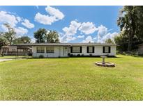 Ranch-style home with a well-maintained lawn and landscaping at 1856 Ne 22Nd St, Ocala, FL 34470