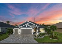 Stunning two-story home with a gray exterior and landscaped yard at 2001 Dagenais Way, The Villages, FL 32163