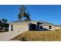 Newly constructed one-story home with gray siding and a two-car garage at 7658 Sw 102Nd Loop, Ocala, FL 34476