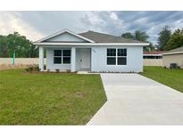Newly built light blue house with a driveway at 10816 Se 66Th Ave, Belleview, FL 34420