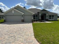 Two-story house with three car garage and brick driveway at 17874 Sw 68Th Pl, Dunnellon, FL 34432