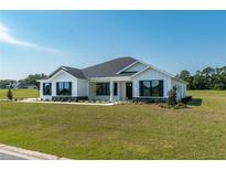 Modern farmhouse exterior with a white exterior and dark trim at 2073 Nw 79Th Loop, Ocala, FL 34475