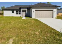 Newly constructed home with gray garage door and a grassy front yard at 4415 Sw 169 Lane Rd, Ocala, FL 34473