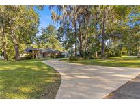 Single-Gathering home with circular driveway and mature trees at 4893 Sw 4Th Cir, Ocala, FL 34471