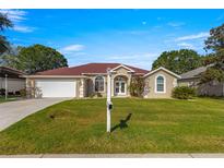 One-story home with a red tile roof and landscaping at 1960 Nw 50Th Cir, Ocala, FL 34482
