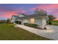 Exterior of house with white walls, tile roof, and a paved walkway at 6042 Topsail Rd, Lady Lake, FL 32159