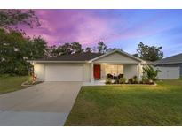 Charming house with a welcoming porch, landscaping, and driveway at 8429 Se 159Th Pl, Summerfield, FL 34491