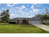 Single-story home with a two-car garage and spacious lawn at 13365 Sw 3Rd Ct, Ocala, FL 34473