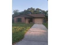 One-story house with a brown brick facade and driveway at 170 Gary Ave, Oak Hill, FL 32759