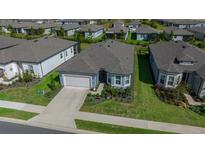 Aerial view of a single-Gathering home with a two-car garage and landscaped yard at 8829 Sw 59Th Lane Rd, Ocala, FL 34481