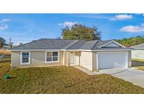 Newly constructed single-story home with a two-car garage and well-maintained lawn at 39 Juniper Trail Cir, Ocala, FL 34480