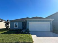 Newly constructed home with a light blue exterior, two-car garage, and well-manicured lawn at 9013 Sw 67Th Ave, Ocala, FL 34476