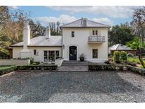 Elegant white two-story home with slate roof, landscaping, and stone driveway at 1150 Sw 43Rd Pl, Ocala, FL 34471