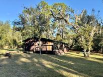 Rustic cabin nestled in a wooded setting with a spacious deck at 45202 Nfs Rd 572-B, Altoona, FL 32702