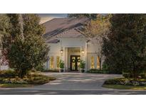 Elegant home with a white exterior, paver driveway, and lush landscaping at 8725 Nw 31St Lane Rd, Ocala, FL 34482