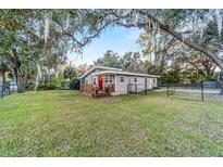 Gray house with wood deck, fenced yard, and mature trees at 208 Se 32Nd Ave, Ocala, FL 34471