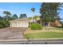 Beautiful home with three car garage, lush landscaping, and brick paver driveway at 17819 Sw 61St Lane Rd, Dunnellon, FL 34432