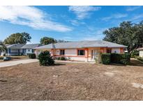 Single story home with gray roof, peach accents, and a neatly trimmed front yard at 6011 Sw 98Th Street Rd, Ocala, FL 34476