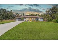Ranch style home with gray exterior, attached garage, and well-manicured lawn at 15330 Sw 59Th Ct, Ocala, FL 34473
