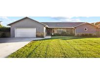 Gray house with brick accents, attached garage, and well-manicured lawn at 2880 Se 34Th St, Ocala, FL 34471