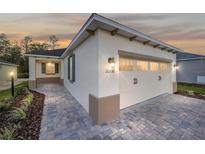 New home exterior boasts a two-car garage and attractive landscaping at 10330 Sw 99Th Ln, Ocala, FL 34481