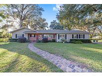 Ranch-style home with brick accents, mature trees, and a brick walkway at 1416 Se 17Th Ave, Ocala, FL 34471