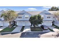 Three-unit townhome building with light blue exterior, two-car garages, and landscaping at 4500 Sw 52Nd Cir # 104, Ocala, FL 34474