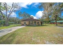 Charming single story home with a stone facade and a well-maintained lawn at 6556 Se 173Rd Ct, Ocklawaha, FL 32179