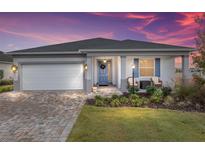 One-story home with gray siding, white garage door, and landscaped front yard at 8916 Sw 78Th Street Rd, Ocala, FL 34481